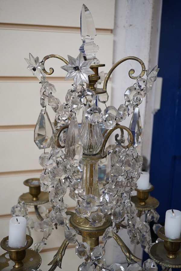 A pair of brass four branch candelabra with glass drops, 61cm high. Condition - fair
